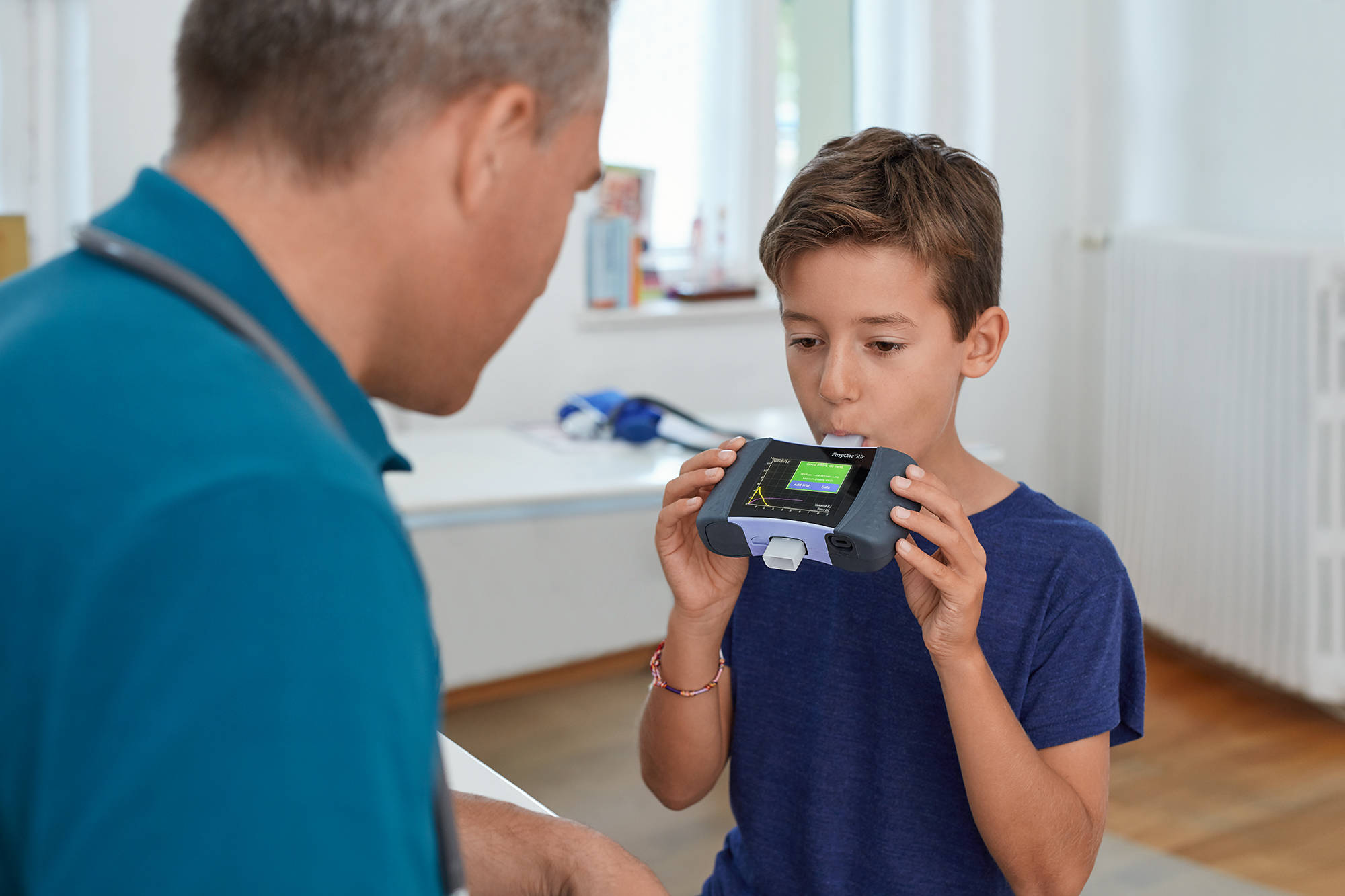 Ung pojkte testar lungkapacitet med en spirometer